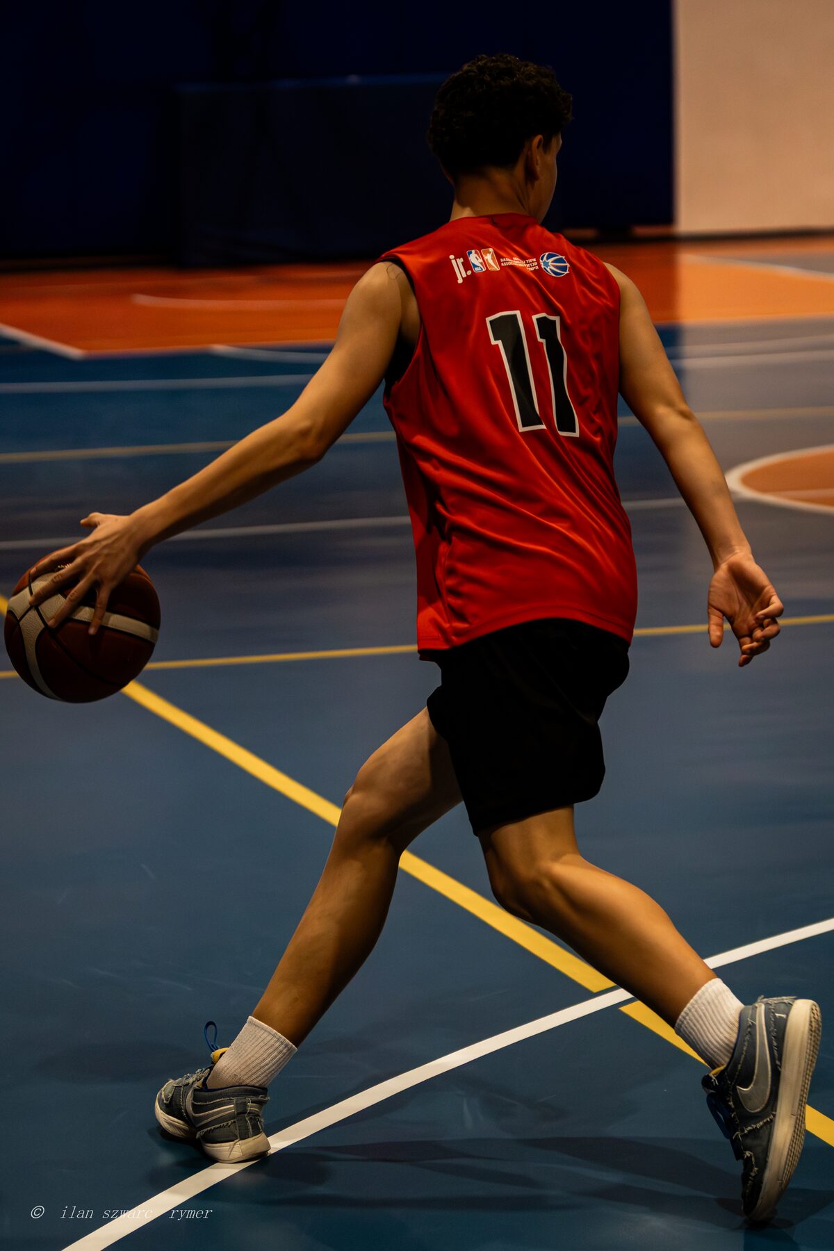Basketball player driving forward mid-dribble