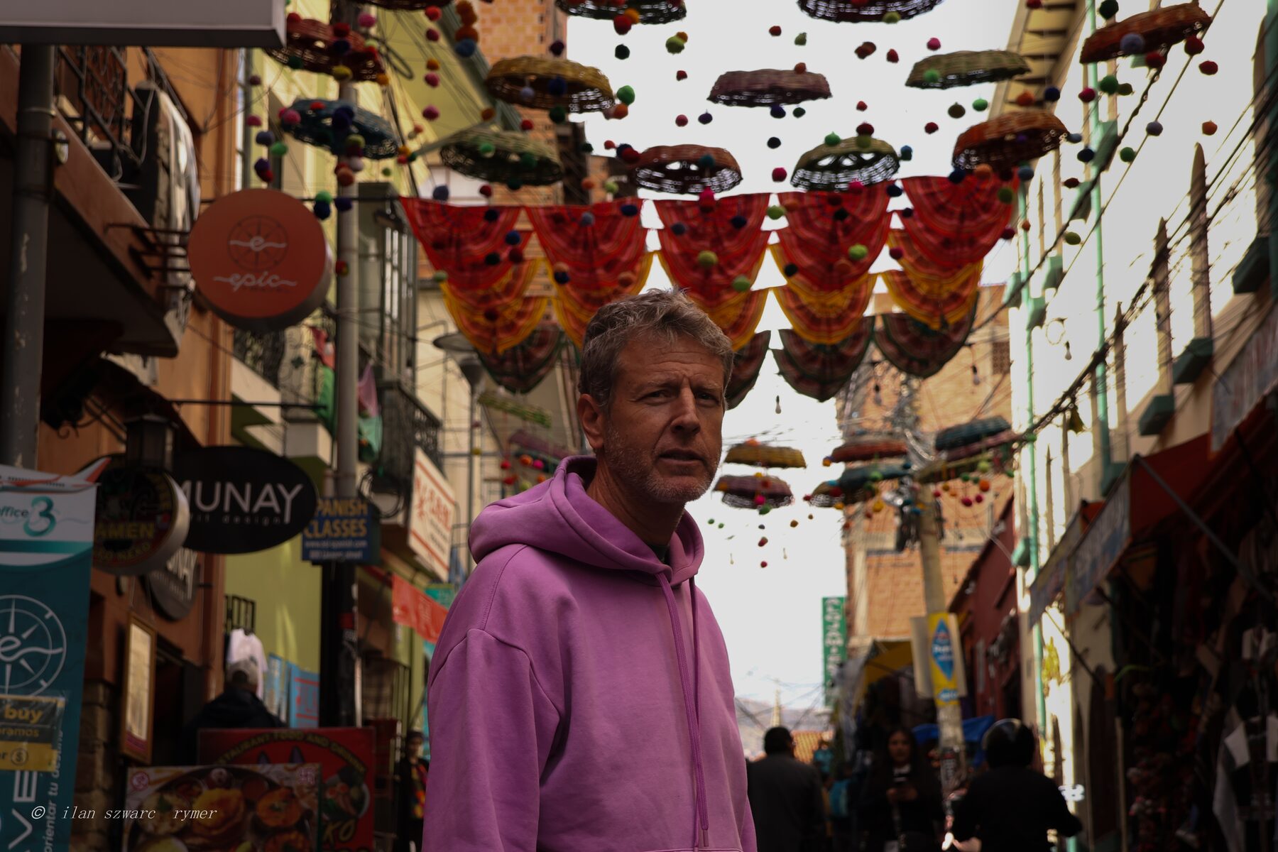 Street portrait under a decorated market alley